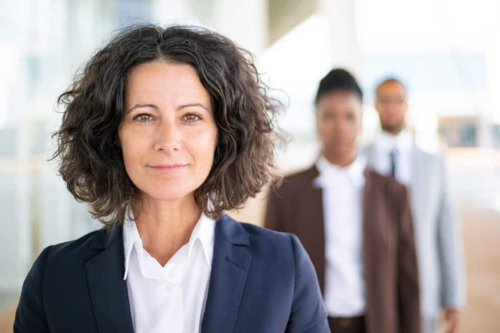 Successful female leader posing with her team